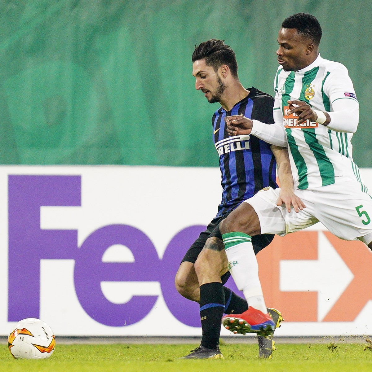 epa07370666 Inter Milan's Matteo Politano (L) in action against Rapid's Boli Bolingoli (R) during the UEFA Europa League round of 32 first leg soccer match between SK Rapid Vienna and Inter  ...