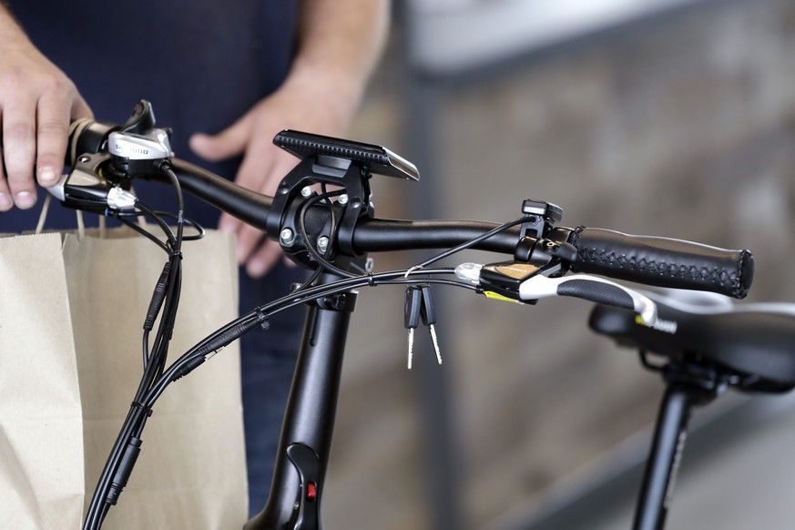 In this photo taken Wednesday, May 15, 2019, a Rad Power Bikes sales associate stands with an electric bicycle he&#039;s delivering to a customer at the shop in Seattle, where the bicycle company said ...