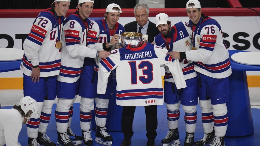 Team USA players hold the trophy and the jersey of the late Johnny Gaudreau after winning the final match between United States and Switzerland at the ice hockey world championships in Stockholm, Swed ...