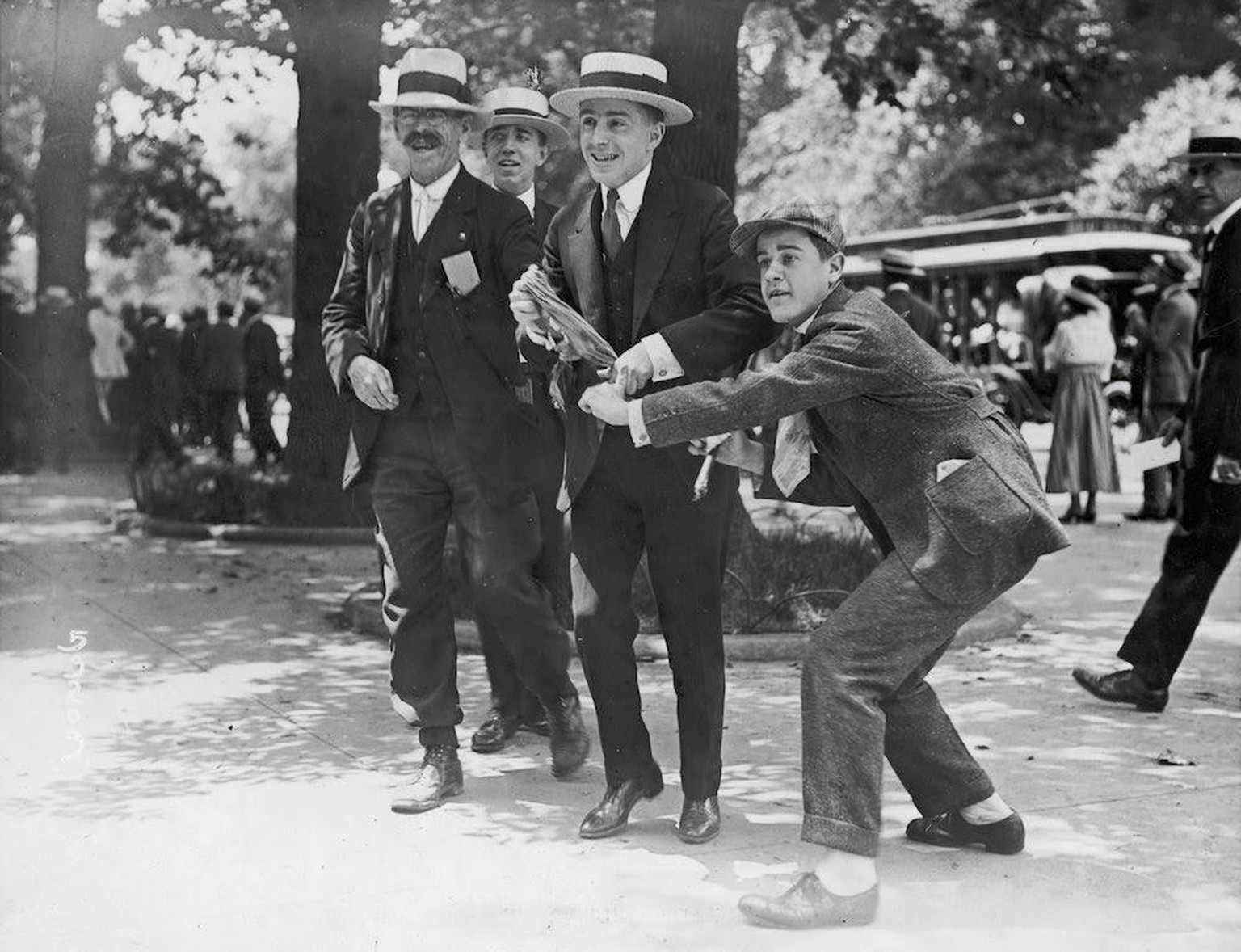 Group of anti women suffragist men tear up the banner of one, White House, Washington DC, 1917.