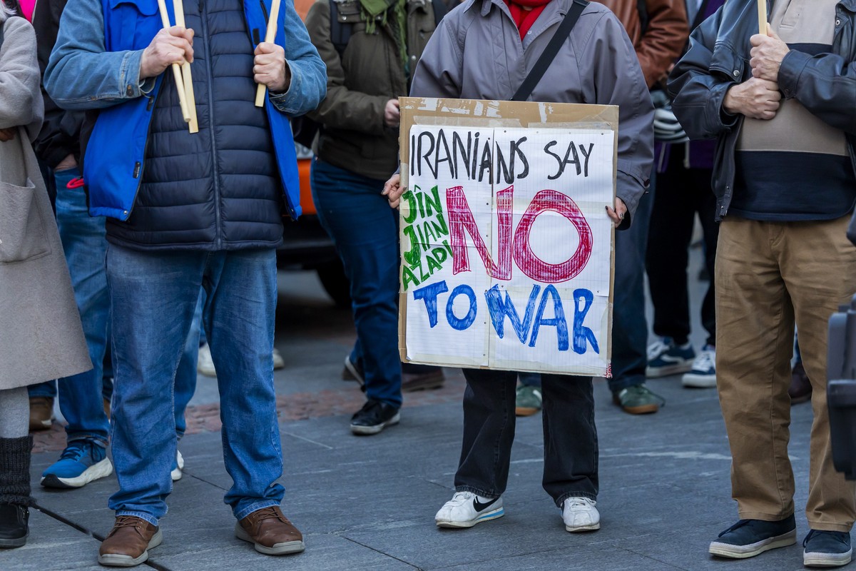 KEYPIX - A woman holds a placard reading "Iranians say no war" and shouts slogan "Stop war in Iran" after U.S. and Israeli military strikes in Iran during an antiwar demonstration, ...