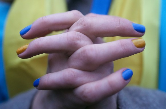 FILE - A woman, her fingernails painted in the colors of the Ukrainian national flag, takes part in a protest against the escalation of the tension between Russia and Ukraine, near the Russian embassy ...