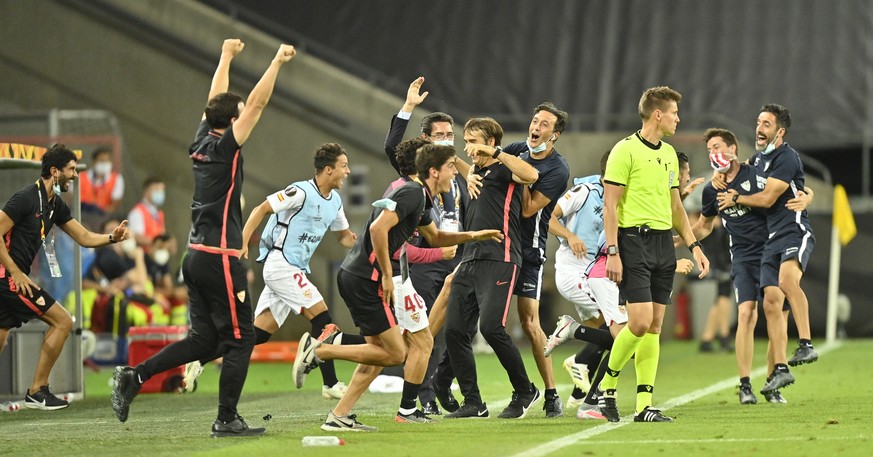 epa08608281 Players of Sevilla celebrate winning the UEFA Europa League semi final match between Sevilla FC and Manchester United in Cologne, Germany, 16 August 2020. EPA/Martin Meissner / POOL