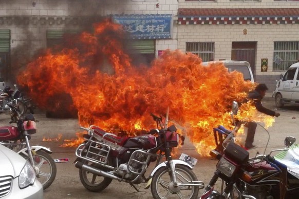 FILE - In this file image made from amateur video footage released by the Tibetan Youth Congress, a Tibetan runs in flames in his self-immolation to protest against Chinese rule, on a street in Yushu  ...