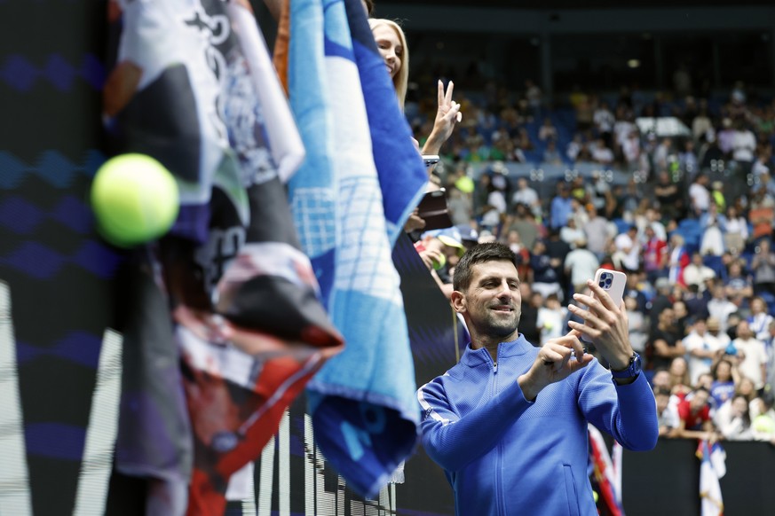 epa11093282 Novak Djokovic of Serbia takes a selfie with spectators after winning his match against Adrian Mannarino of France during the Men&#039;s 4th round match at the Australian Open tennis tourn ...