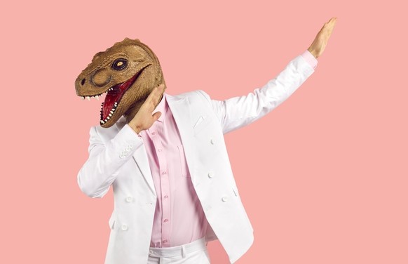 Mann macht Party mit Dino-Maske.