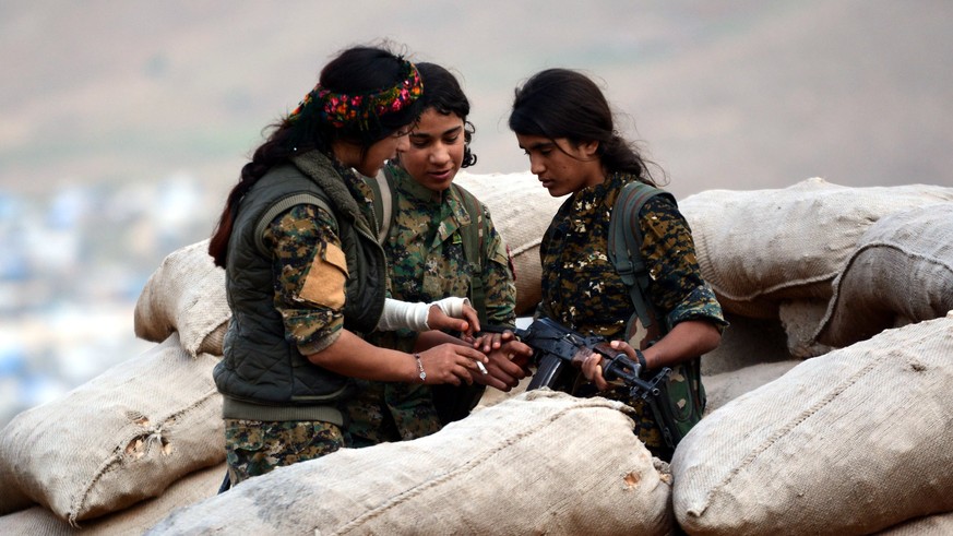 epa06664477 Syrian and Iraqi Kurdish female fighters of the Women&#039;s Protection Units (YPJ) and Rojava Defence Units take up position at a military barracks near the northern Iraqi town of Sinjar, ...