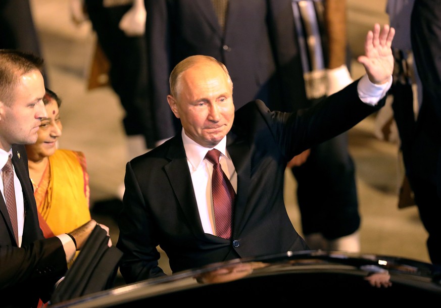 epa07069131 Russian president Vladimir Putin (C) waves to spectators upon his arrival in New Delhi, India, 04 October 2018. President Putin is on a two days visit to India during which he is scheduled ...