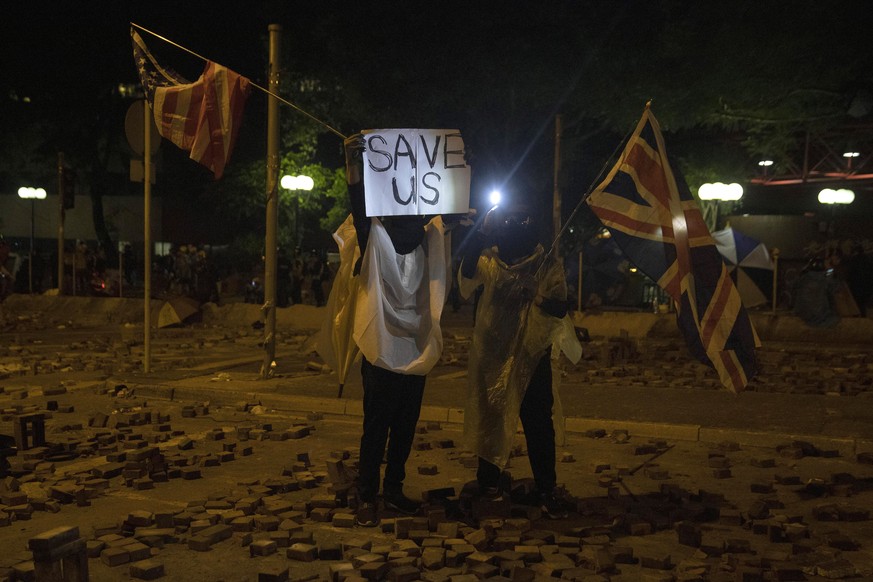 Protesters holds up a message to journalists as they prepare for police action against Hong Kong Polytechnic University in Hong Kong Monday, Nov. 18, 2019. Fiery explosions were seen early Monday as H ...