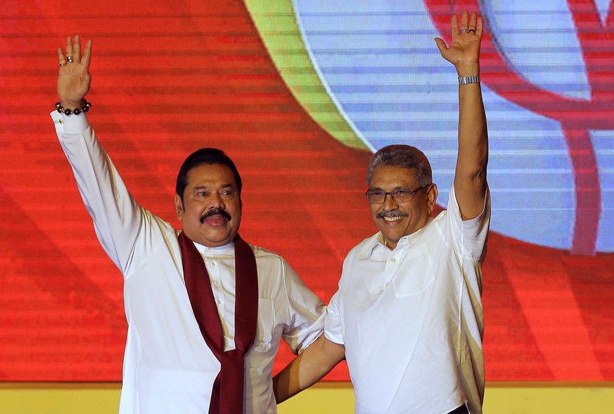 FILE - Mahinda Rajapaksa, left, and his brother Gotabaya Rajapaksa wave to supporters during a party convention held to announce the presidential candidacy in Colombo, Sri Lanka, Aug. 11, 2019. Sri La ...
