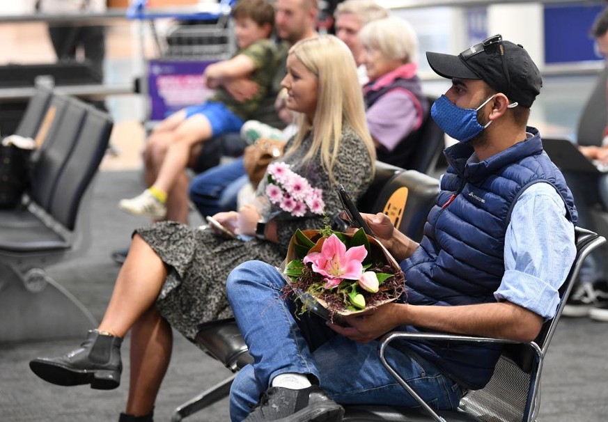 AUCKLAND, NEW ZEALAND - APRIL 19: Friends and relatives wait for passengers arriving from Australia at Auckland Airport on April 19, 2021 in Auckland, New Zealand. The trans-Tasman travel bubble betwe ...