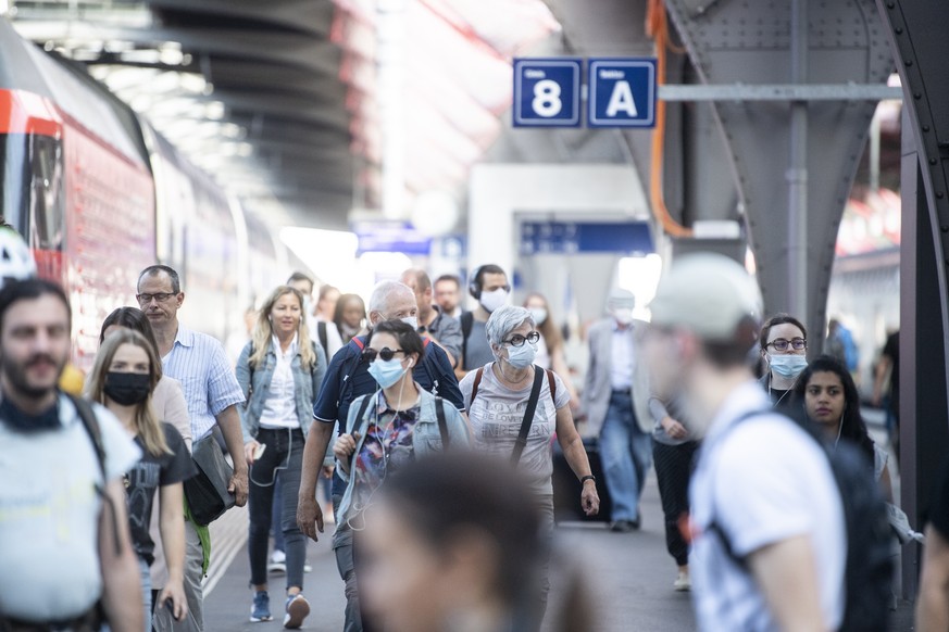 Pendler mit Atemschutzmasken bewegen sich auf dem Hauptbahnhof in Zuerich, aufgenommen am Montag, 6. Juli 2020. (KEYSTONE/Ennio Leanza)