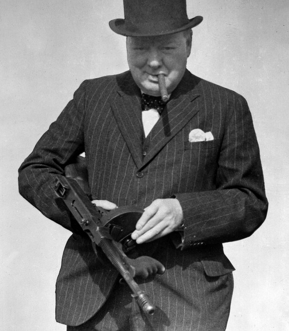 This is a Aug. 1, 1940 photo provided by the British government, Britain's Prime Minister Winston Churchill tries a Tommy Gun during a visit to north-east England. Churchill Britain's famous World War ...
