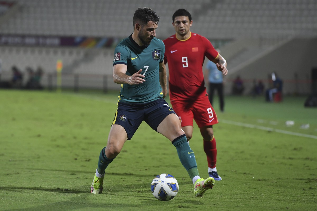 Australia's Mathew Leckie, front, and China's Kesen Ai fight for the ball during a a qualifying soccer match for the FIFA World Cup Qatar 2022 between China and Australia in Sharjah, the Uni ...