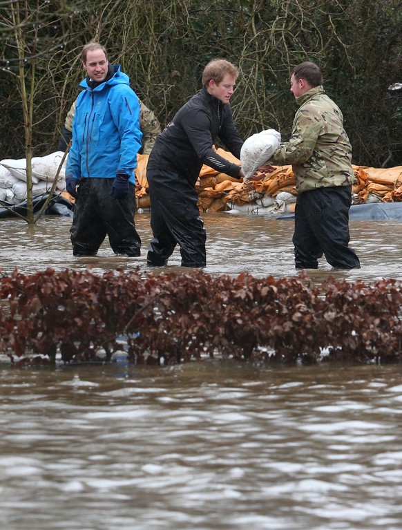 Die Prinzen William und Harry halfen beim Sandsackschleppen.