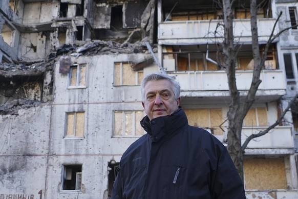 UN High Commissioner for Refugees, Filippo Grandi stands near a damaged residential building after Russian shelling in Kharkiv, Ukraine, Tuesday, Jan. 24, 2023. (AP Photo/Andrii Marienko)