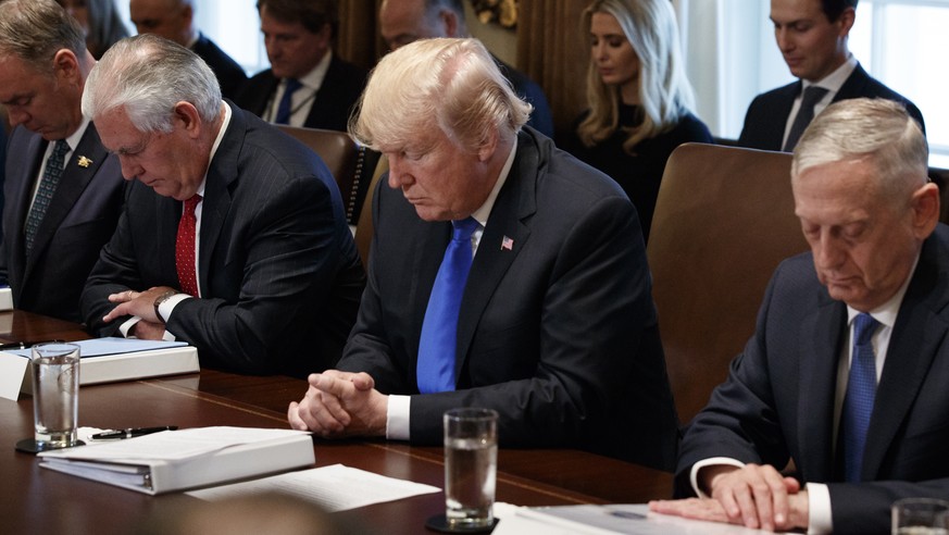 President Donald Trump prays during a cabinet meeting at the White House, Wednesday, Dec. 20, 2017, in Washington. From left, Secretary of Interior Ryan Zinke, Secretary of State Rex Tillerson, Trump, ...