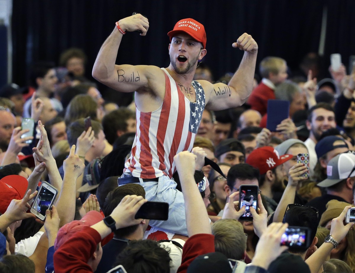 FILE - In this April 15, 2016, file photo, a Donald Trump supporter flexes his muscles with the words "Build The Wall" written on them as then-Republican Presidential candidate Donald Trump  ...