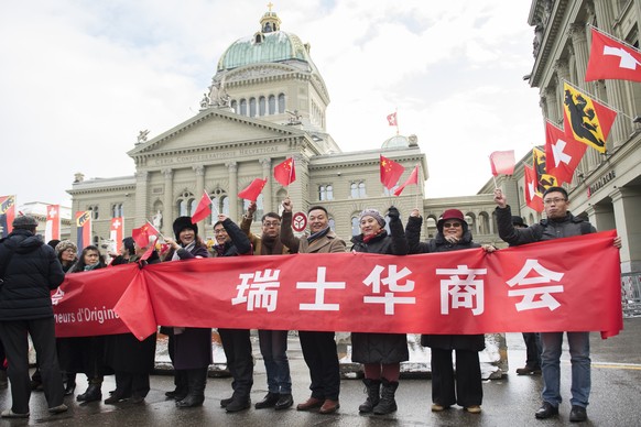 People with Chinese flags and banners are waiting in front of the House of Parlament for the visit of China&#039;s President Xi Jinping (not pictured) to Switzerland, in Bern, on Sunday, January 15, 2 ...