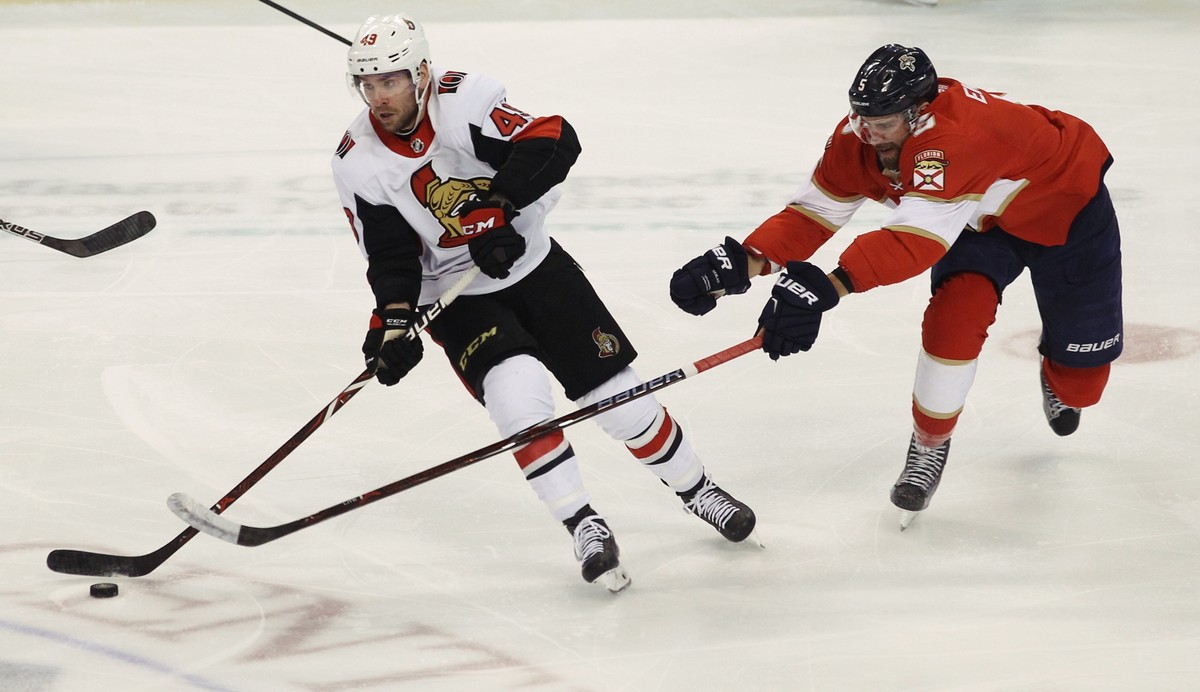 Ottawa Senators' Christopher DiDomenico, left, moves the puck as Florida Panthers' Aaron Ekblad, right, defends during the first period of an NHL hockey game, Saturday, Dec. 23, 2017, in Sun ...