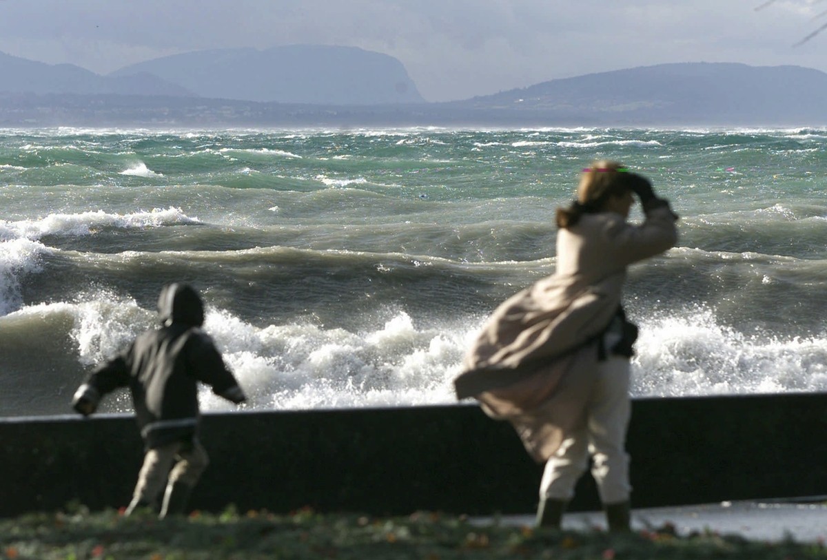 Des passants observent le spectacle des vagues sur le Lac Leman, ce dimanche 26 decembre 1999 a Lausanne. La Suisse entiere a ete touche par des rafales de vent de plus de 100 km/h. Plusieures personn ...