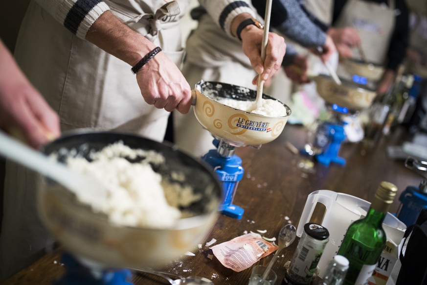 Competitors prepare their cheese fondue during the first qualifying round of the second World Cheese Fondue competition in Tartegnin, Switzerland, Saturday November 18 2017. The event aims to reward t ...