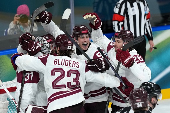 Latvia goalkeeper Arturs Silovs (31) celebrates with Teodors Blugers (23), Kristians Rubins (94) and Uvis Balinskis (26) after defeating Germany 4-3 in a men's ice hockey preliminary round match  ...
