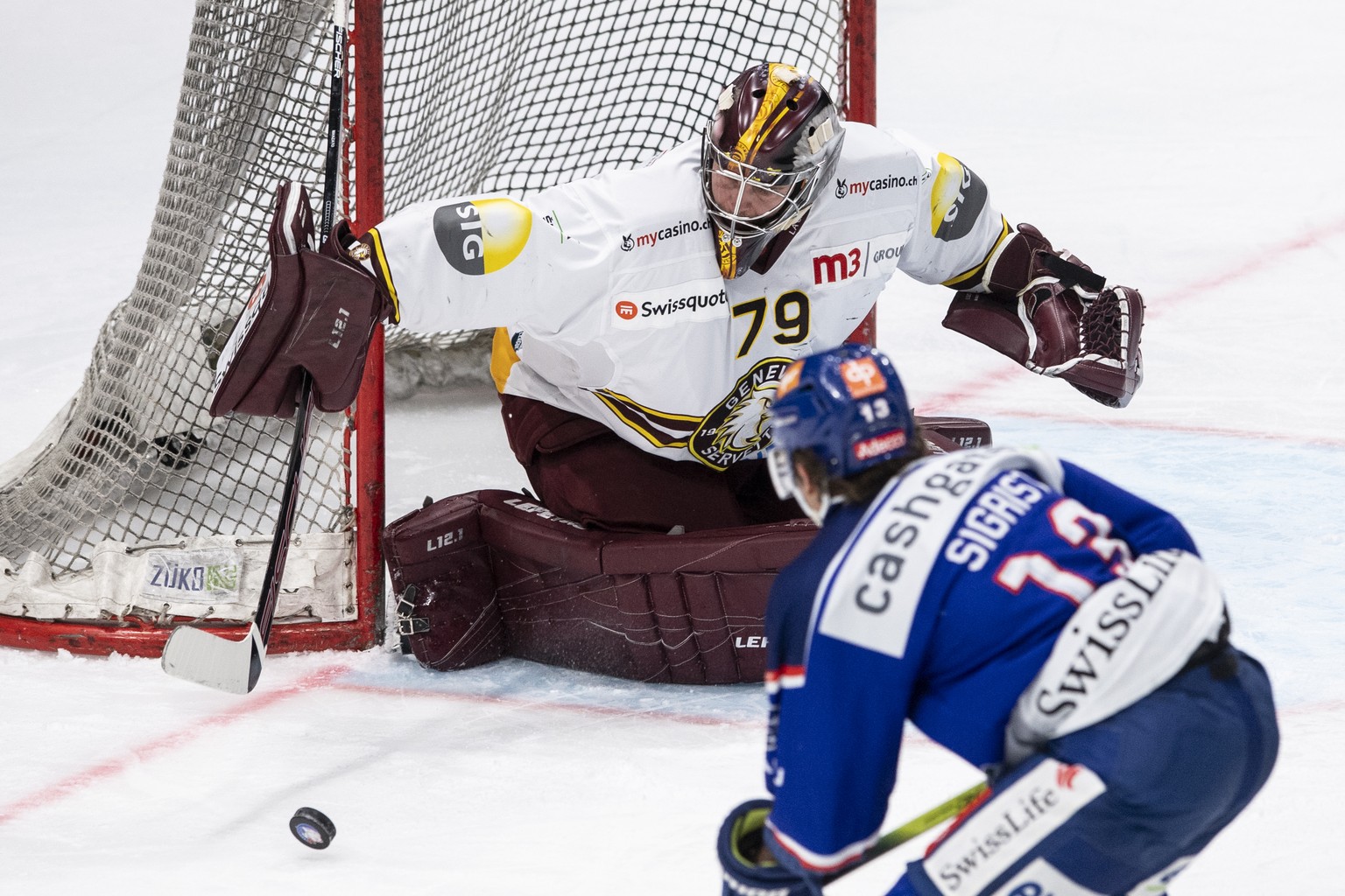 Servettes Torhueter Daniel Manzato, links, kaempft um den Puck gegen Zuerichs Justin Sigrist, rechts, im ersten Eishockey Playoff-Halbfinalspiel der National League zwischen den ZSC Lions und dem Gene ...