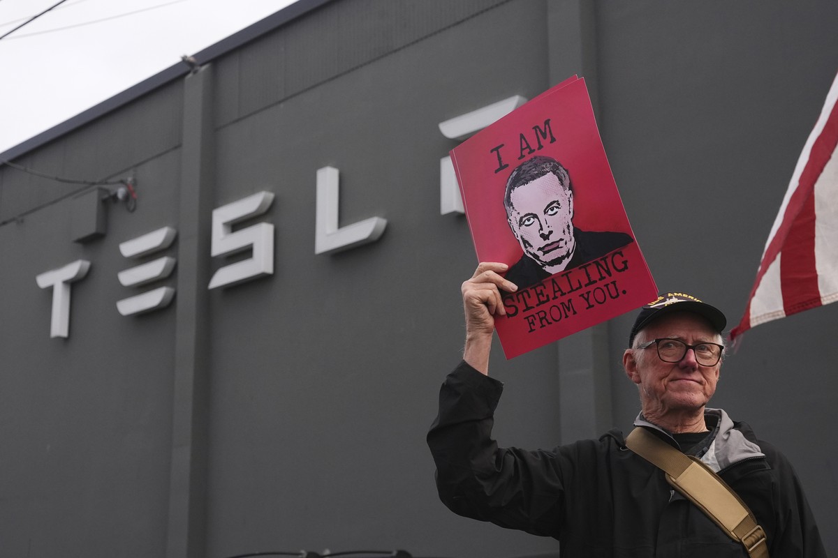 A person waves a sign depicting Elon Musk during a protest against Musk and Tesla Saturday, March 29, 2025, in Seattle. (AP Photo/Lindsey Wasson)
Tesla Protests