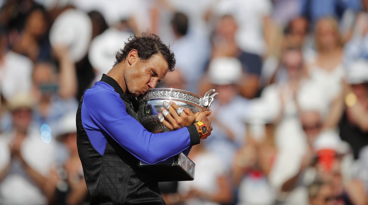 Spain's Rafael Nadal kisses the trophy as he celebrates winning his tenth French Open title against Switzerland's Stan Wawrinka in three sets, 6-2, 6-3, 6-1, during their men's final ma ...