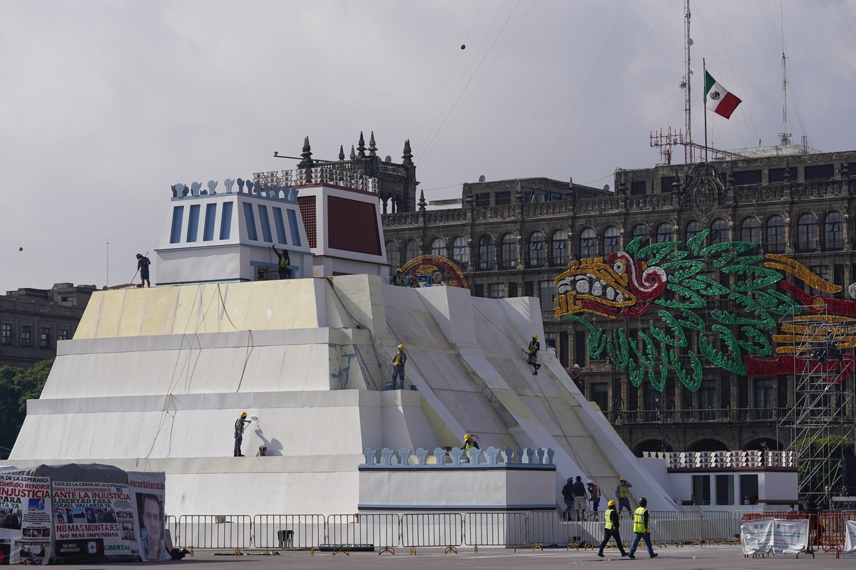 Workers build a replica of the Aztec Templo Mayor, with an image of the Pre-columbian god Quetzalcoatl adorning the surrounding buildings, at Mexico City's main square the Zocalo, Monday, Aug. 9, ...