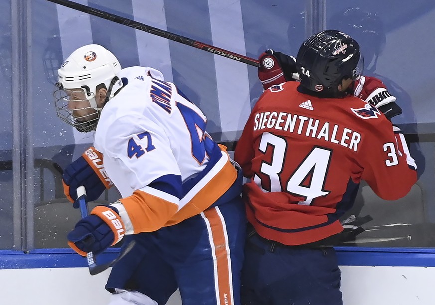 New York Islanders right wing Leo Komarov (47) hits Washington Capitals defenseman Jonas Siegenthaler (34) during the second period of an NHL Eastern Conference Stanley Cup hockey playoff game in Toro ...