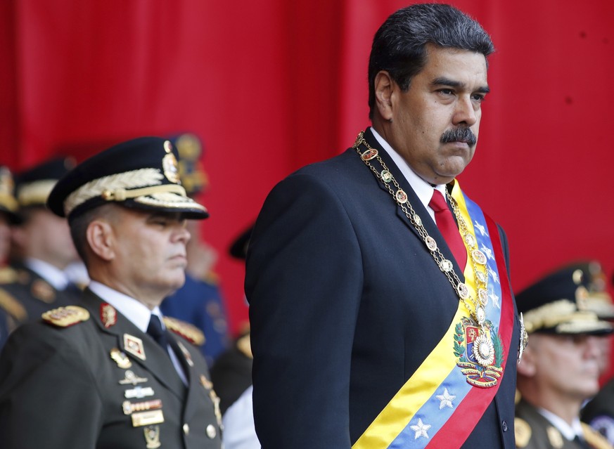 FILE - In this May 24, 2018 file photo, Venezuela&#039;s President Nicolas Maduro watches a military parade, alongside his Defense Minister Vladimir Padrino Lopez, behind, at Fort Tiuna in Caracas, Ve ...