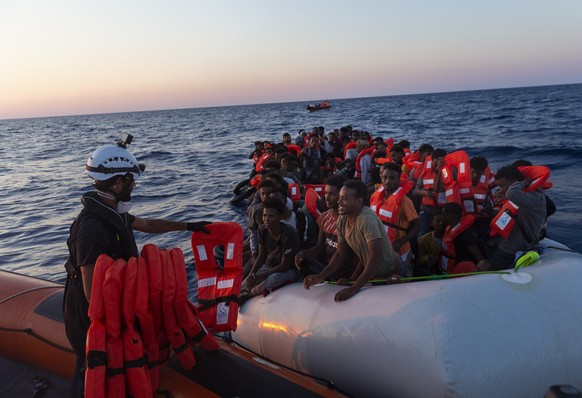 Crew of the Sea-Watch 3 distribute life jackets to 108 people in a boat in distress in the central Mediterranean on Saturday, July 23, 2022. Ships in the Mediterranean Sea have rescued over 1,100 peop ...