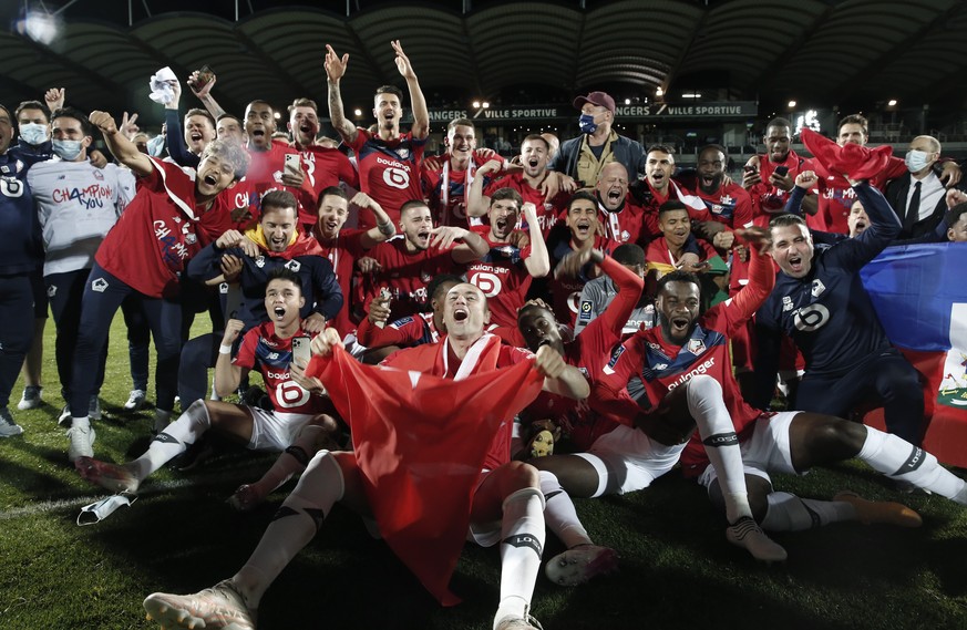 Lille players and coaches celebrate after the French League One soccer match between Angers and Lille at the Raymond Kopa Stadium in Angers, France, Sunday May 23, 2021. Lille won the match 2-1 to cli ...