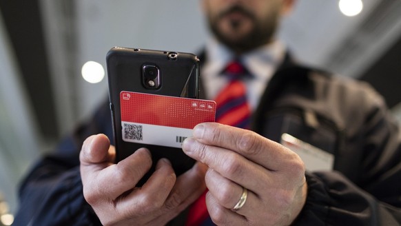 Train manager Salvatore Grado verifies a rail traveller&#039;s Swiss Pass in a Eurocity train of the Swiss Federal Railways bound from Zurich, Switzerland, to Milano, Italy, on October 3, 2015. (KEYST ...