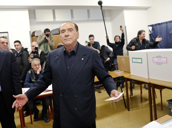 Italian former premier and leader of Forza Italia (Let&#039;s Go Italy) party Silvio Berlusconi listens to reporters at a polling station in Milan, Italy, Sunday, March 4, 2018. More than 46 million I ...