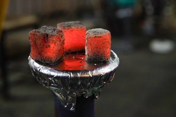 Hookah hot coals on shisha bowl with blur background. hot red coals for Shisha warmed up on the stove in a hookah bar on a dark background. with copy space Model Released Property Released xkwx backgr ...