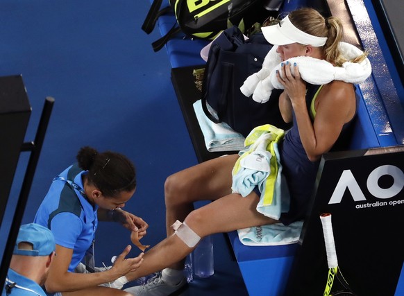 Denmark&#039;s Caroline Wozniacki receives treatment from a trainer during the women&#039;s singles final against Romania&#039;s Simona Halep at the Australian Open tennis championships in Melbourne,  ...