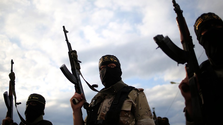 epa04120410 Islamic Jihad militants hold up their weapons during the funeral of three Islamic Jihad militants in Khan Younis, southern Gaza Strip, 11 March 2014. Three Islamic Jihad militants were rep ...