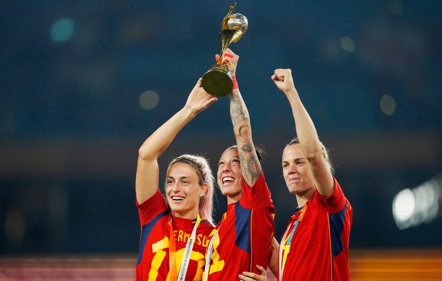 FILE - Spain's Alexia Putellas, Jennifer Hermoso and Irene Paredes ,from left, celebrate with the trophy at the end of the Women's World Cup soccer final between Spain and England at Stadium ...