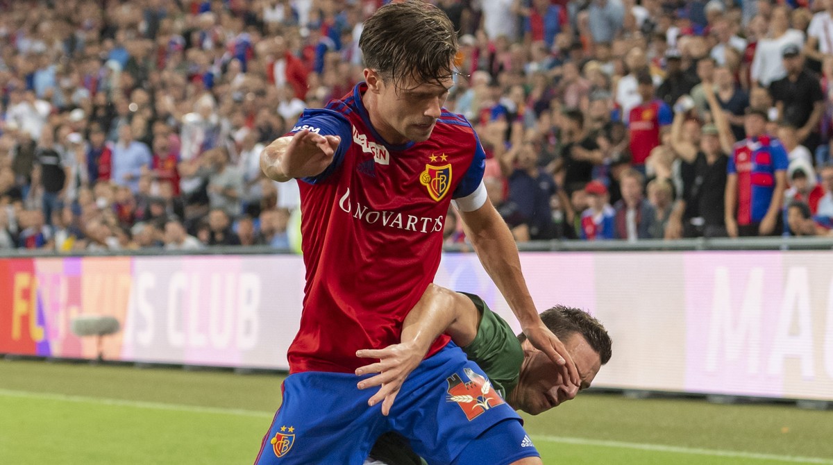 Basel's Valentin Stocker, left, fights for the ball against PSV's Nick Viergever, right, during the UEFA Champions League second qualifying round second leg match between Switzerland's  ...