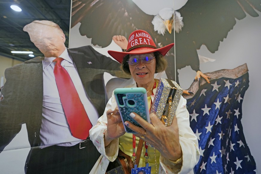 Ramona Ortega of Phoenix, Arizona, looks at her cell phone while attending the Conservative Political Action Conference (CPAC) in Dallas, Thursday, Aug. 4, 2022. Hungarian Prime Minister Viktor Orban  ...