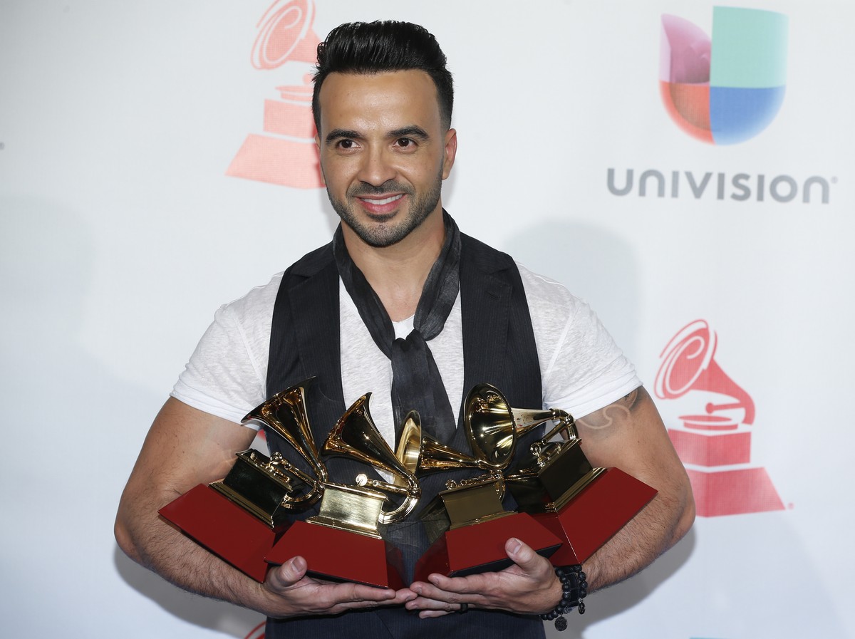 Luis Fonsi poses in the press room with the awards for best urban/fusion/performance, best short form music video, record of the year, and song of the year for "Despacito" at the 18th annual ...