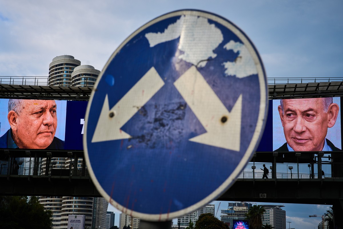 KEYPIX - People cross a bridge beneath a television campaign advertisement featuring Israeli Prime Minister Benjamin Netanyahu, right, and his main rival, opposition candidate Gadi Eisenkot, ahead of  ...