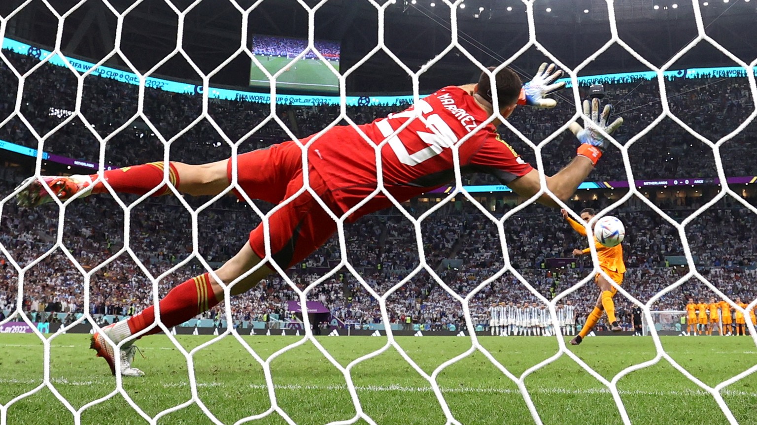 epa10358271 Goalkeeper Emiliano Martinez of Argentina saves the penalty of Virgil van Dijk of the Netherlands in the penalty shoot-out during the FIFA World Cup 2022 quarter final soccer match between ...