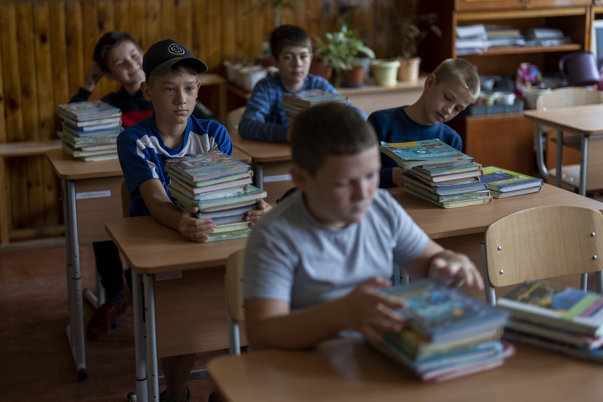 Students sit in a classroom to receive textbooks ahead of this week's beginning of the academic year at Mykhailo-Kotsyubynske's lyceum, which was bombed by Russian forces on the 4th of March ...