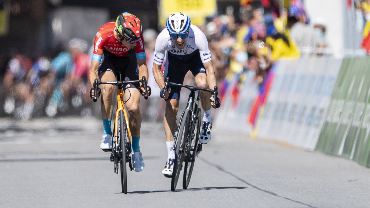 epa09267926 Gino Maeder from Switzerland of Bahrain Victorious, left, and Michael Woods from Canada of Israel Start-Up-Nation, right, at the finish line of the eighth and final stage, a 160 km race wi ...