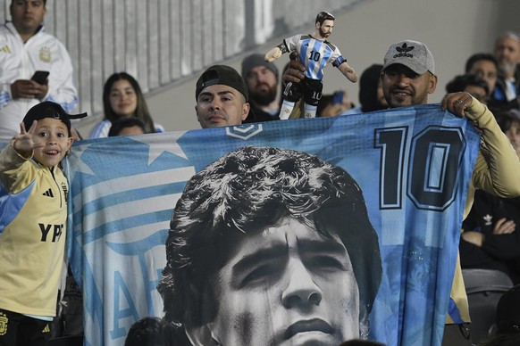 Argentina fans hold a banner with a portrait of Diego Maradona during a qualifying soccer match for the FIFA World Cup 2026 against Chile in Buenos Aires, Argentina, Thursday, Sept. 5, 2024. (AP Photo ...