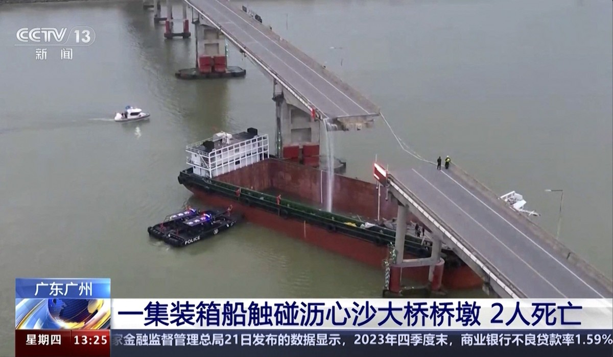 In this image from video released by China's CCTV, people inspect the broken Lixinsha Bridge after being hit by a container ship in Nansha District of Guangzhou, south China's Guangdong Prov ...